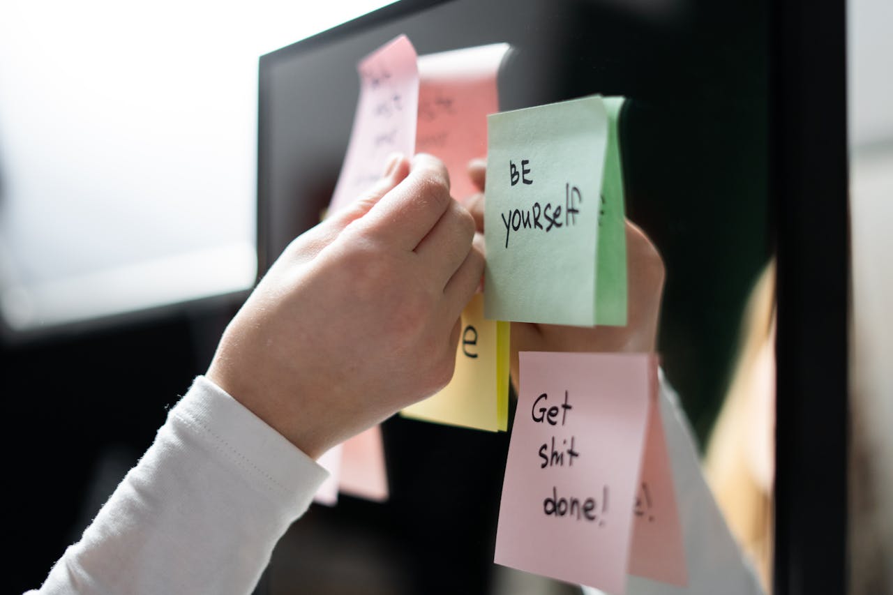 Person Holding White and Pink Sticky Notes